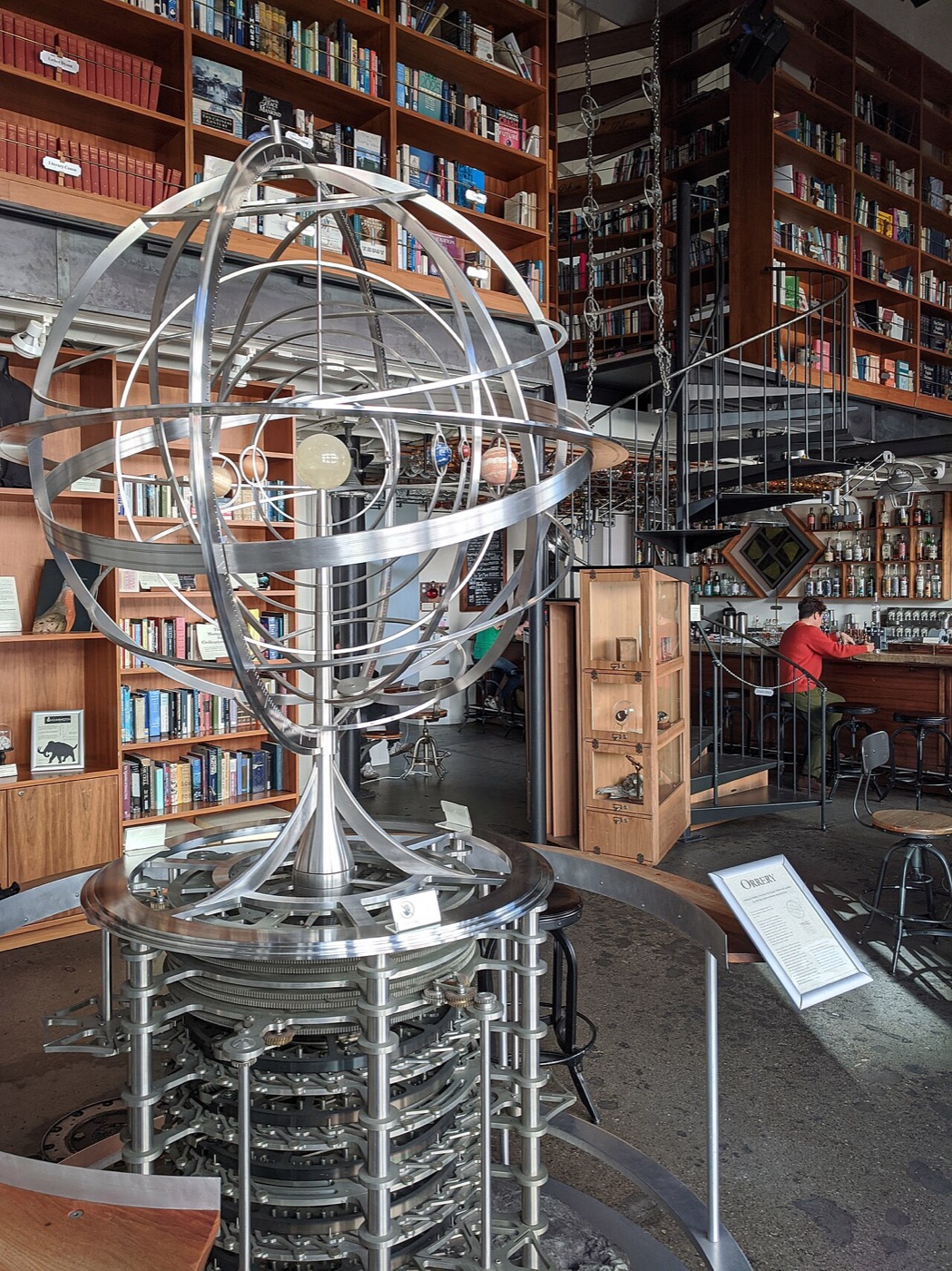 The bar at the Interval in Fort Mason, with round bottles of gin hanging from the ceiling racks